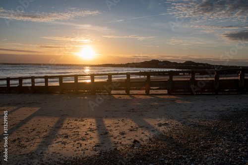 Beautiful Sunset Littlehampton Seafront  Sun casting long shadows on the sandy beach as it slip towards the horizon.