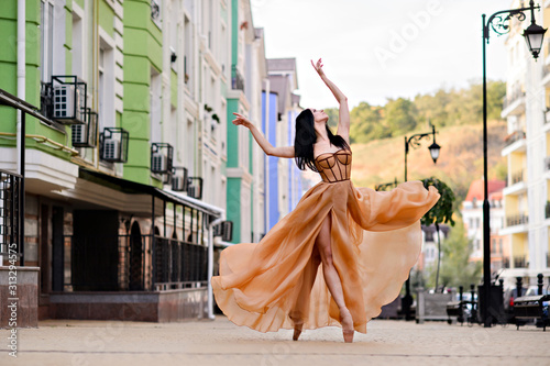 Elegant ballet dancer young girl dancing ballet outdoors. photo