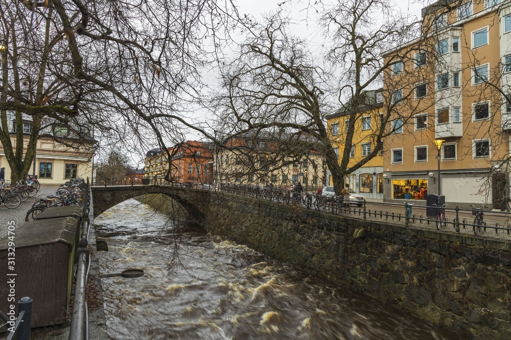 Gorgeous view on  street near river on background. Gorgeous sky with thunderclouds on a winter day.  Tourism, travel concept. Europe, Sweden, Uppsala.