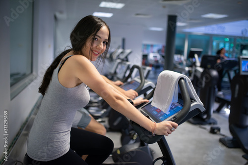 Woman training in a gym using a stationaty bike
