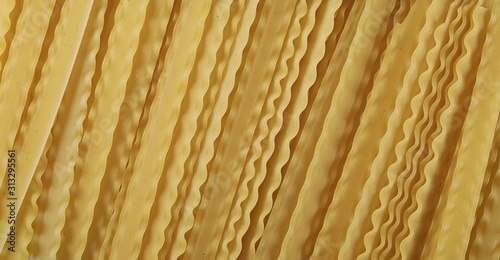 Uncooked Italian pasta mafaldine background and texture