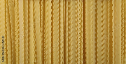Uncooked Italian pasta mafaldine background and texture