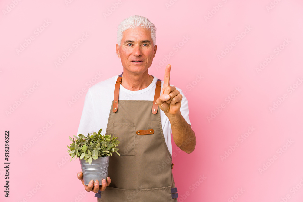Middle aged gardener man isolated showing number one with finger. Middle aged gardener man isolated showing number one with finger.