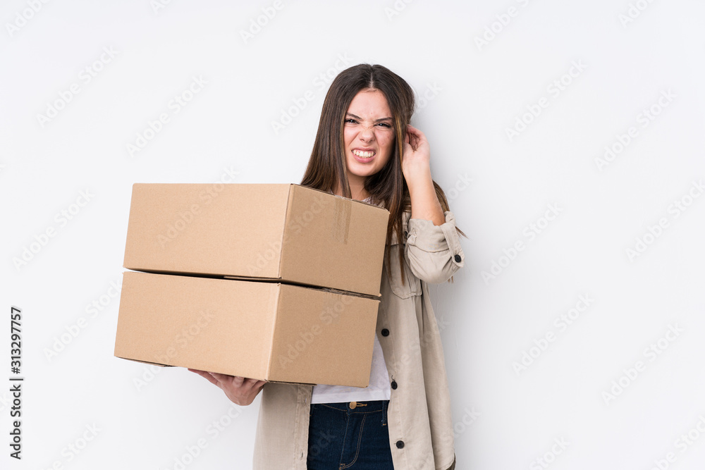 Young caucasian woman moving to a new home covering ears with hands. Young caucasian woman moving to a new home covering ears with hands.