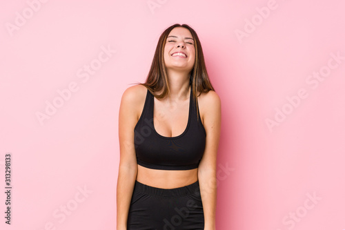 Young fitness caucasian woman isolated laughs and closes eyes, feels relaxed and happy. © Asier