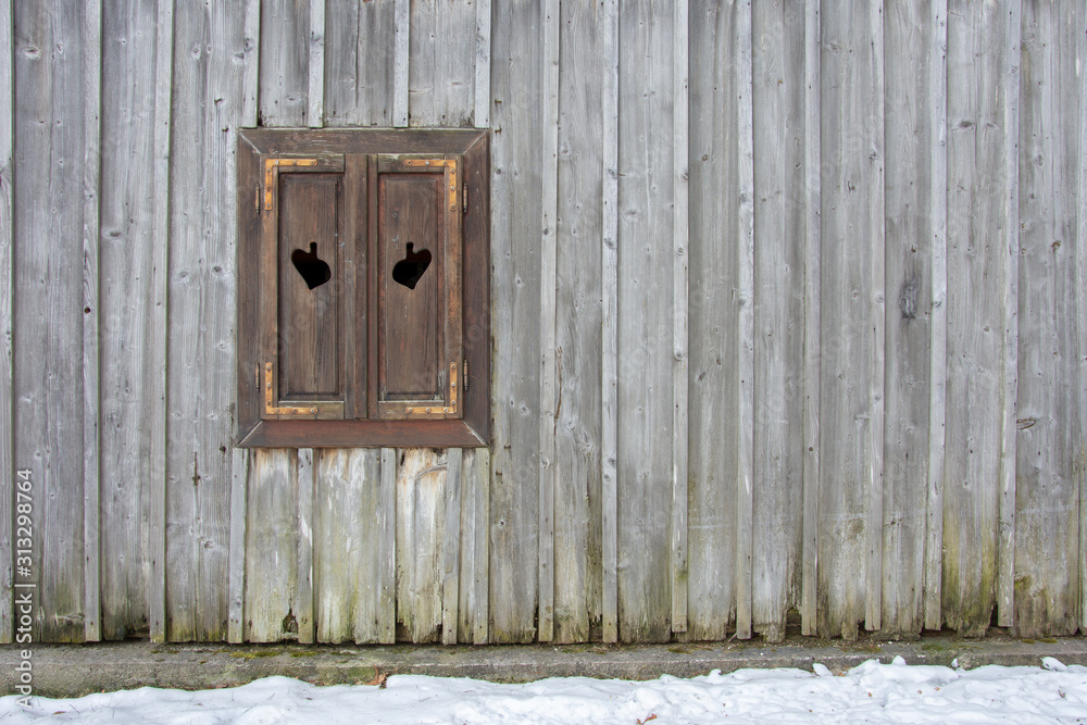 Wooden wall on the building with one window on it. Background with many copy space.