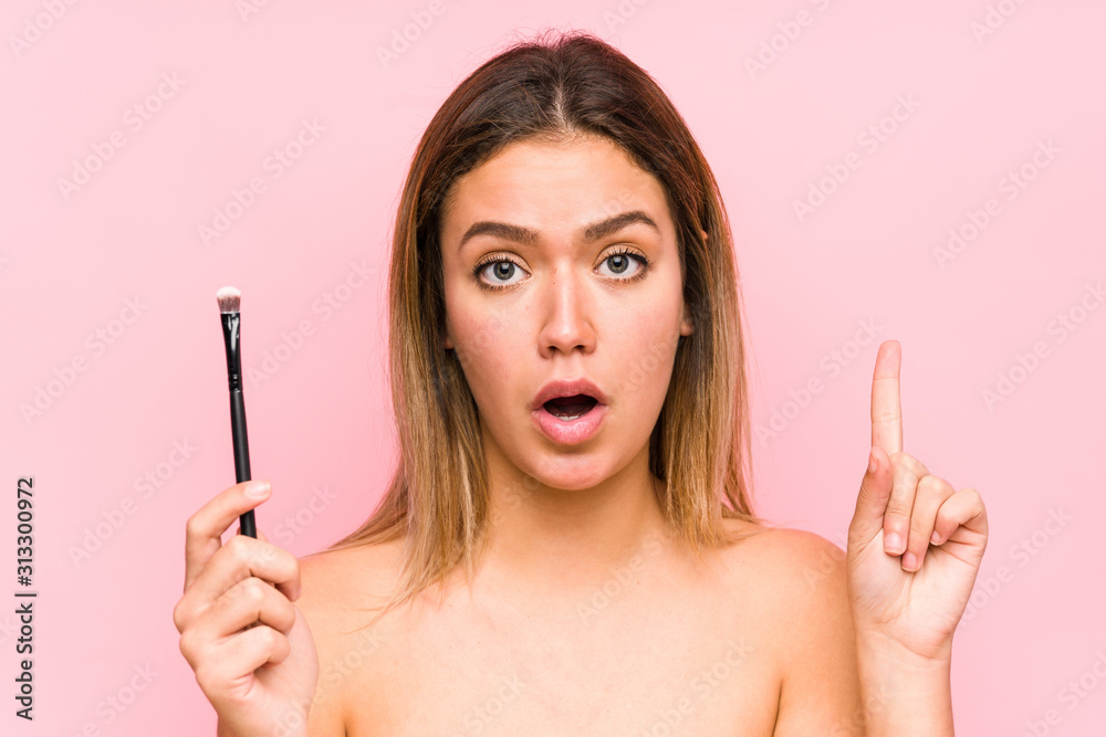 Young caucasian woman holding a eyebrush isolated having some great idea, concept of creativity. Young caucasian woman holding a eyebrush isolated having some great idea, concept of creativity.