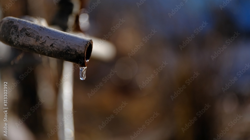 Water flows from an old rusty metal pipe. Malfunction in the water supply system. Water leak Water flows from an old rusty metal pipe. Malfunction in the water supply system. Water leak