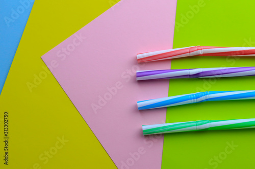 Plastic cocktail straws on color background