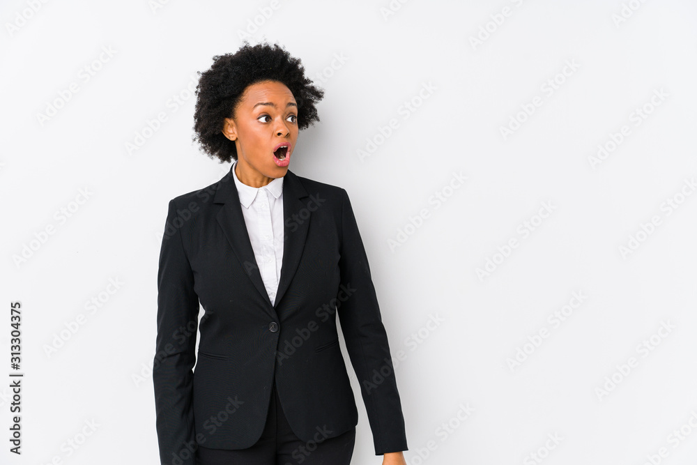 Middle aged african american business woman against a white background isolated being shocked because of something she has seen. Middle aged african american business woman against a white background isolated being shocked because of something she has seen.