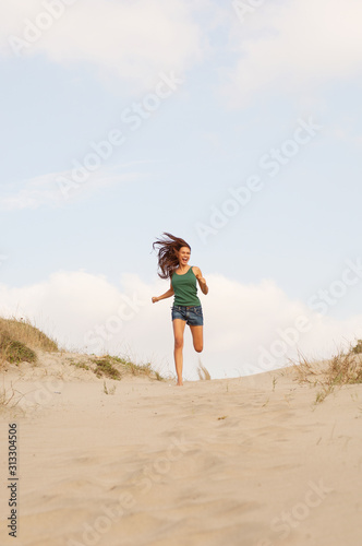 Ragazza bella corre sulla sabbia