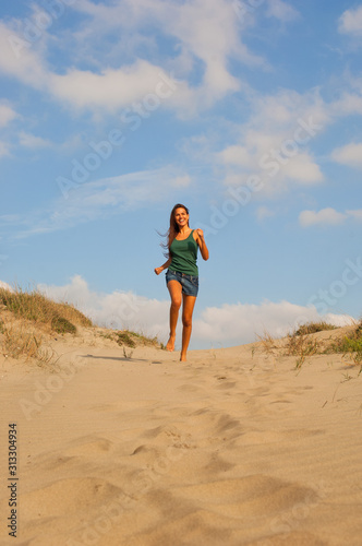 Giovane donna corre sulla spiaggia