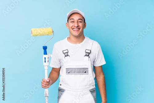 Young professional painter latin man isolated laughing and having fun. photo