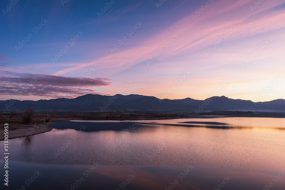 Beautiful color sunset landscape with swamp lake, with reflections of calm blurred water
