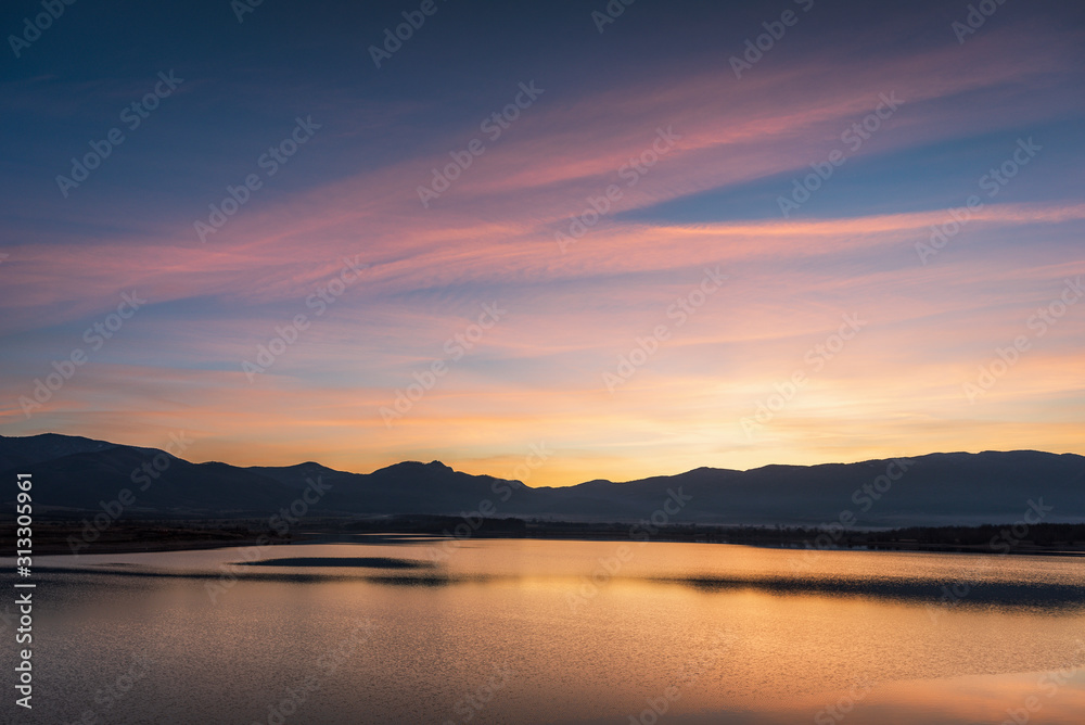 Beautiful lake view on sunset. With water, mountain and colorful clouds