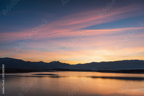 Beautiful lake view on sunset. With water, mountain and colorful clouds