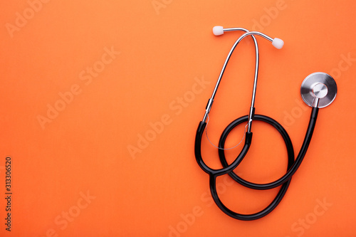Medical stethoscope on a orange background. Health care concept photo