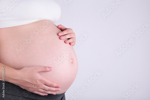 A cute pregnant belly on a grey background