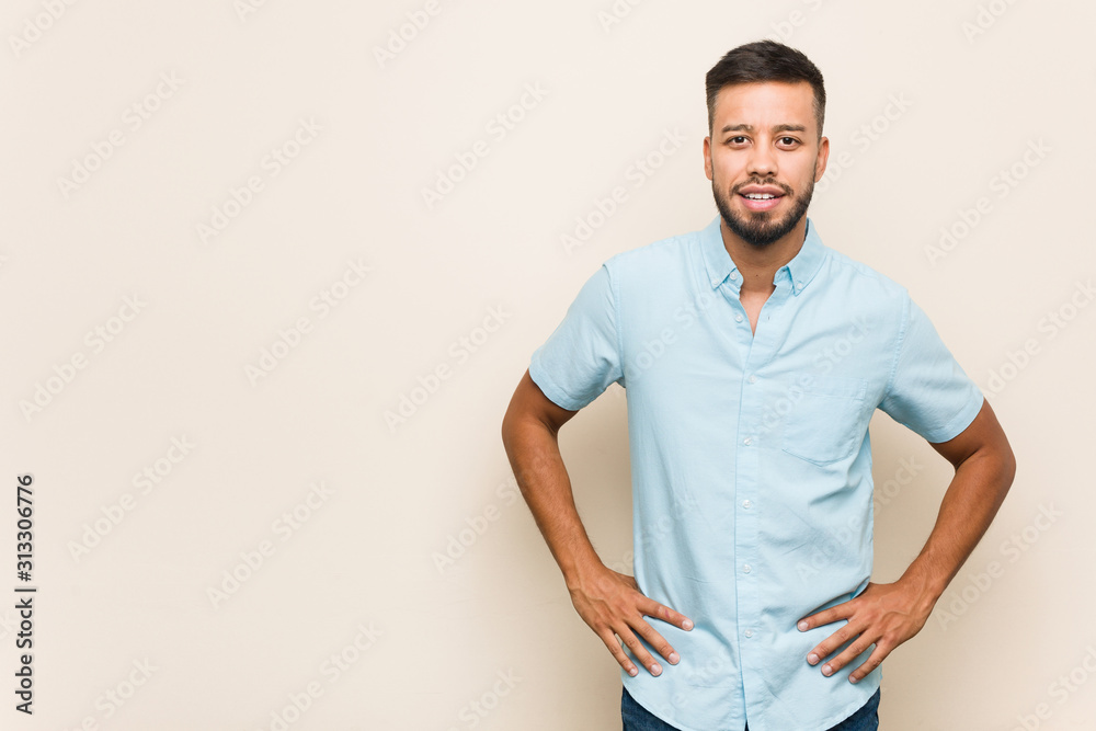 Young south-asian man confident keeping hands on hips. Young south-asian man confident keeping hands on hips.