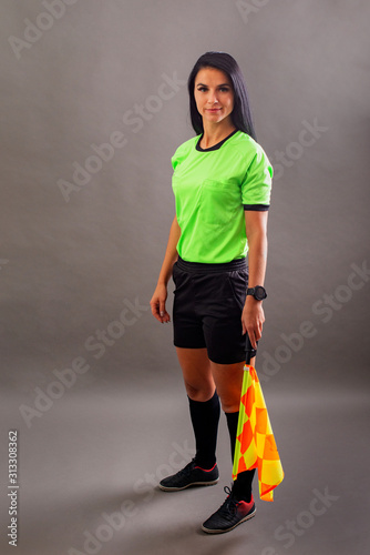 Beautiful Soccer Referee with flag in hand looking at camera and smile