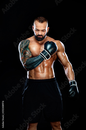 Fitness and boxing concept. Boxer, man fighting or posing in gloves on black background. Individual sports recreation. © Mike Orlov