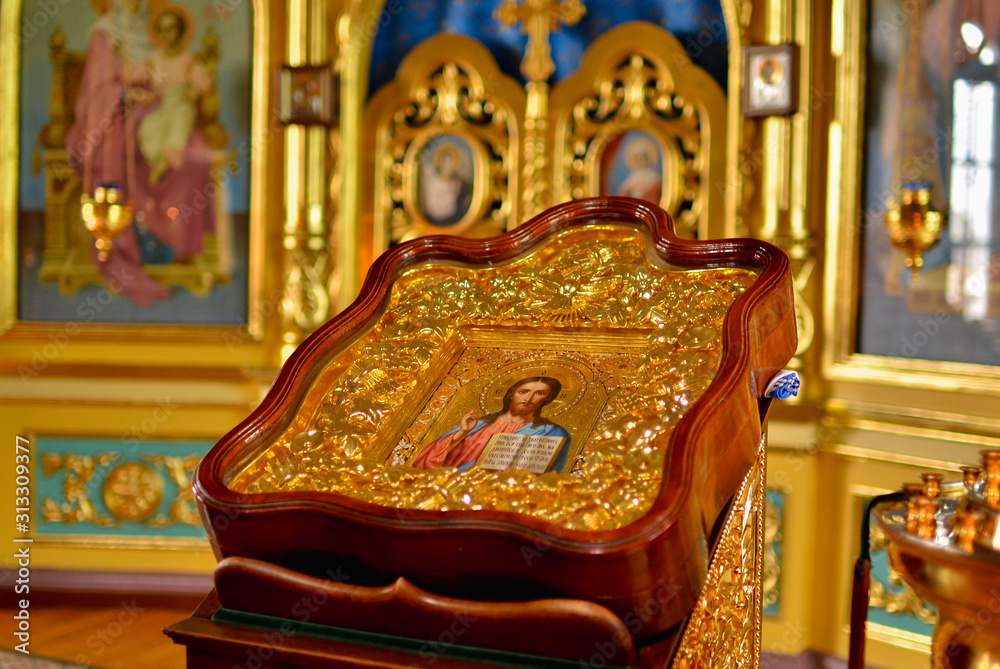 Icon of Jesus in a large wooden frame. Temple with golden frescoes. Icon of Jesus in a large wooden frame. Temple with golden frescoes.