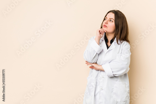 Young doctor woman looking sideways with doubtful and skeptical expression. photo