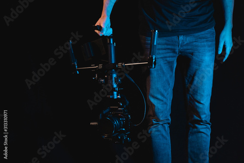 Photos Filmmaker camera operator with dark background