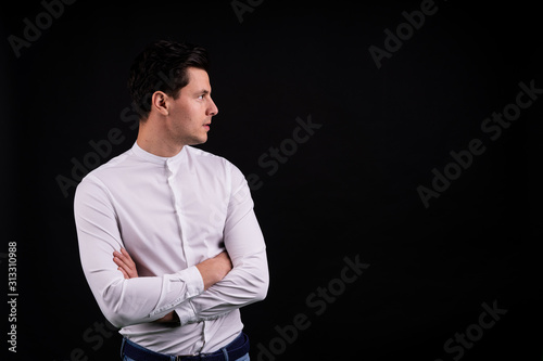 a young man looks away and thinks. isolated from the black background