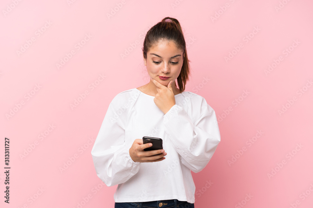Young brunette girl over isolated pink background thinking and sending a message Young brunette girl over isolated pink background thinking and sending a message
