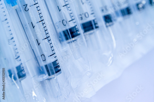 Medical syringes in packaging as an abstract background. Medical syringes in a package.