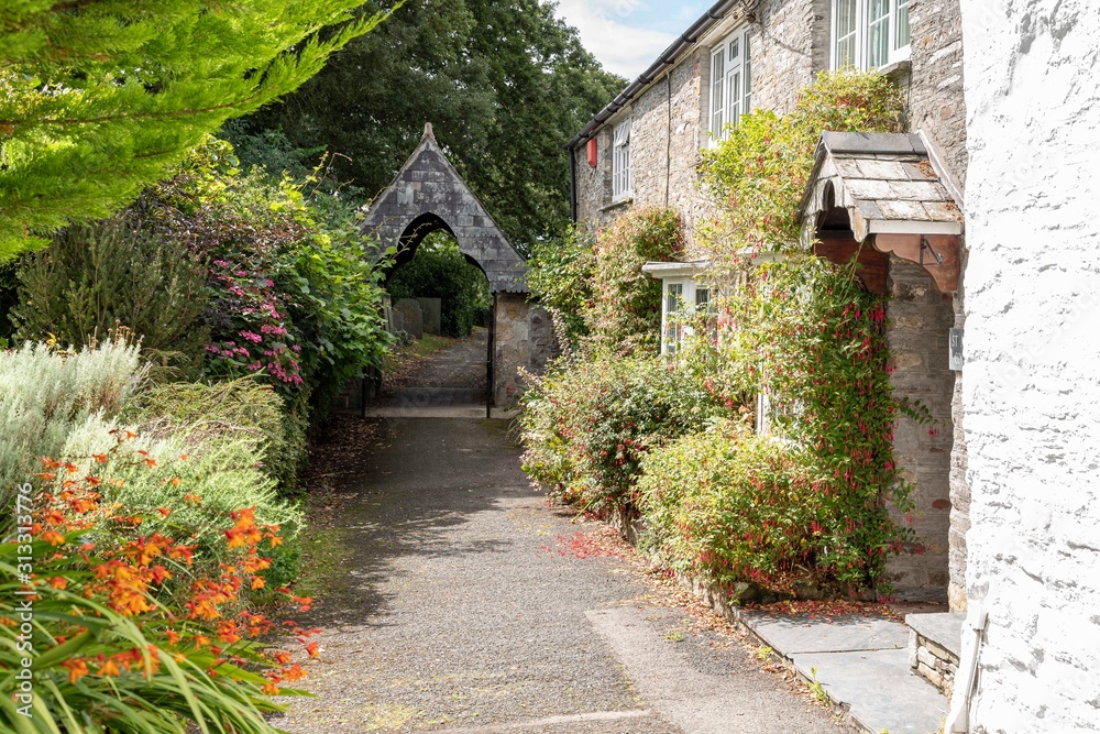 St. Minver, Cornwall, England UK: A sunny and quiet country village path with cottages and flowers.
