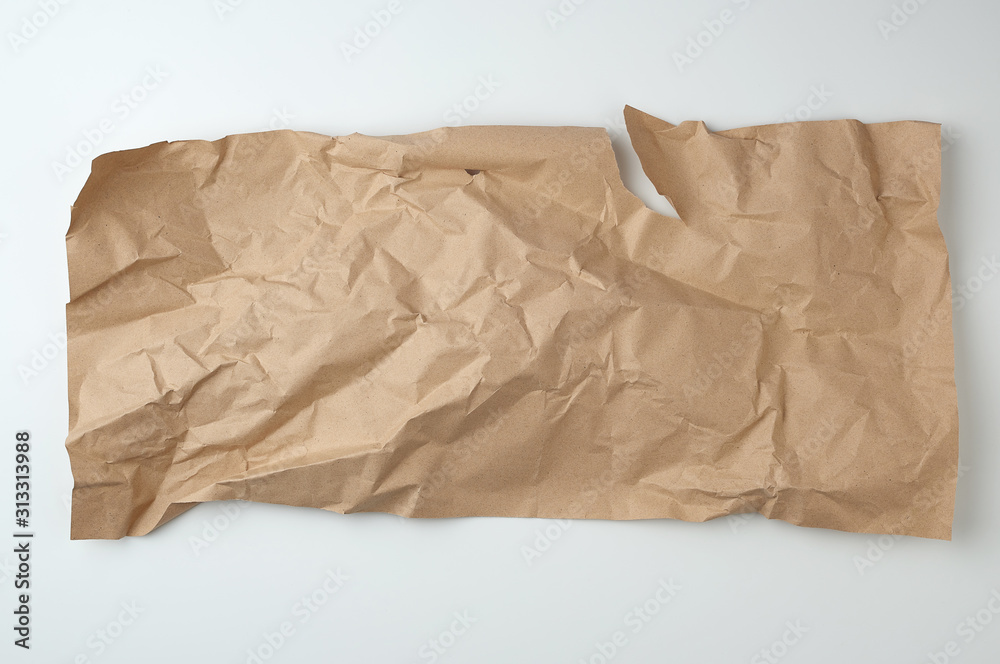 crumpled brown sheet of paper for packaging goods on white background