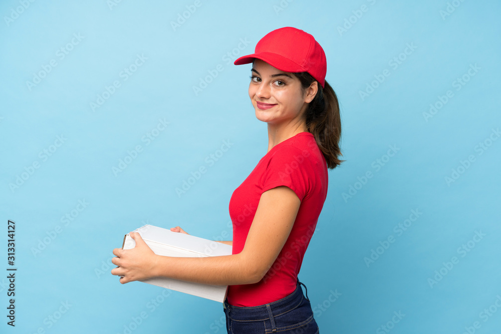 © luismolinero - Young woman holding a pizza over isolated pink wall laughing