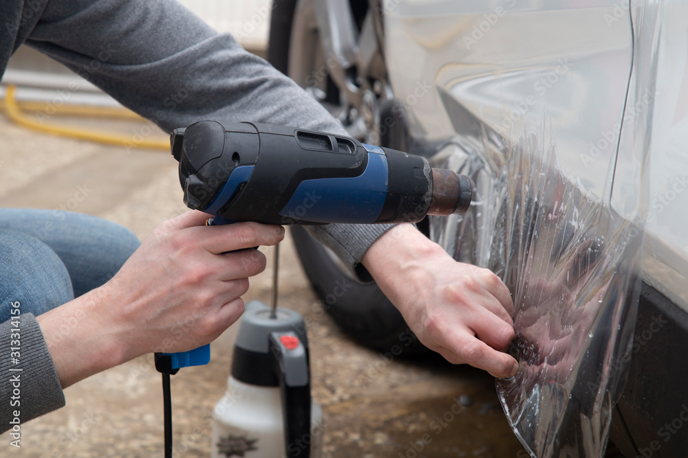 Installing a protective film on the car body to protect the paint on the car.