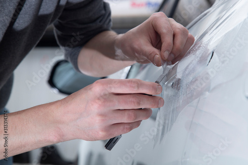 Installing a protective film on the car body to protect the paint on the car.