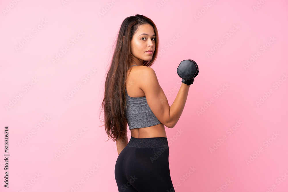 Young sport Brazilian girl over isolated pink background making weightlifting Young sport Brazilian girl over isolated pink background making weightlifting