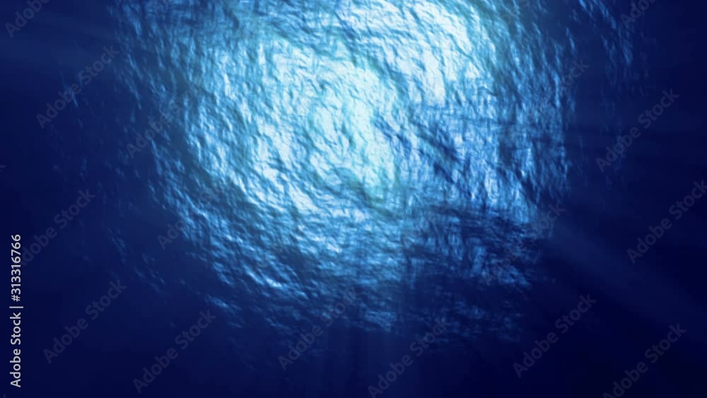 Under the deep blue sea, looking up at gentle waves on the surface with sun rays breaking through. Loopable footage.