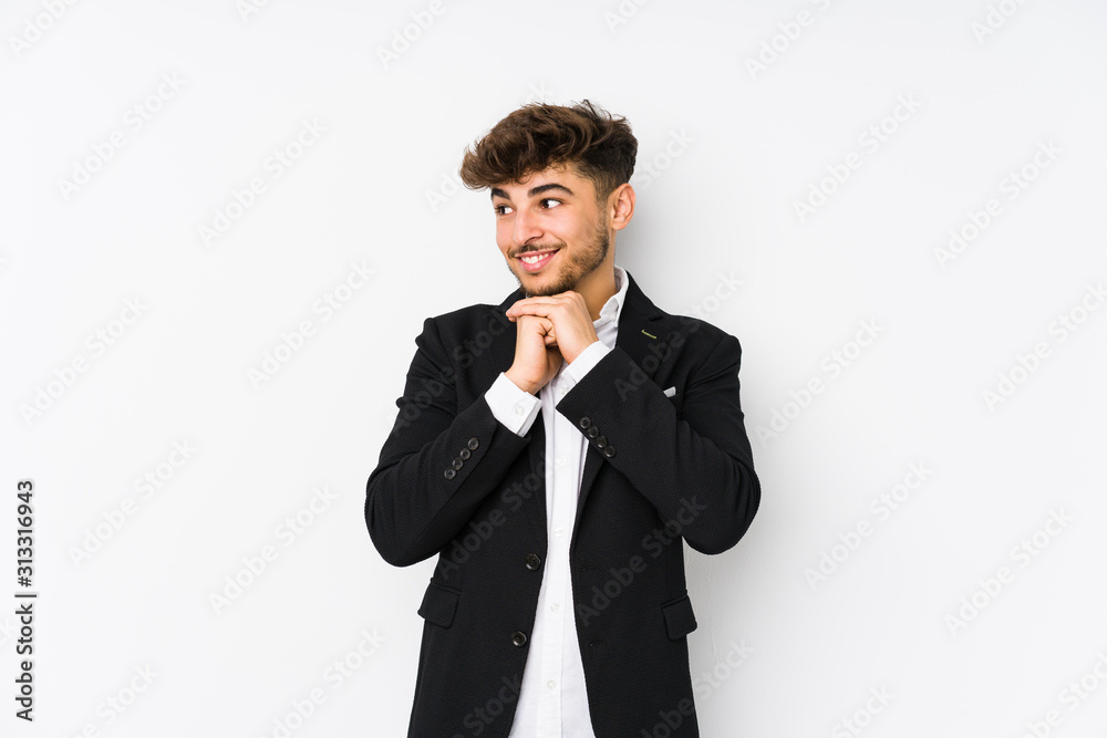 Young arabian business man isolated keeps hands under chin, is looking happily aside. Young arabian business man isolated keeps hands under chin, is looking happily aside.