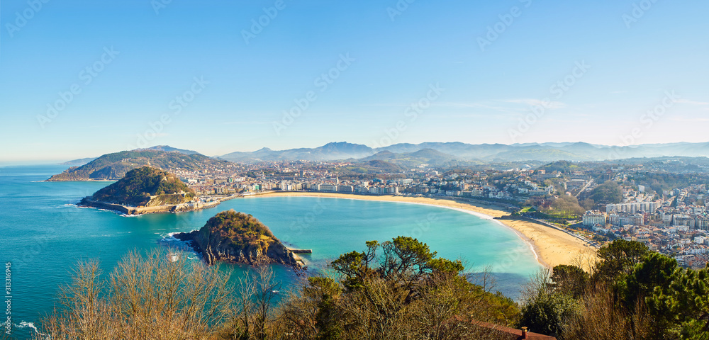 Naklejka premium Panoramiczny widok na zatokę Concha. Plaża Concha, plaża Ondarreta i wyspa Santa Clara z Monte Igueldo w słoneczny dzień. San Sebastian (Donostia), Kraj Basków, Guipuzcoa. Hiszpania.