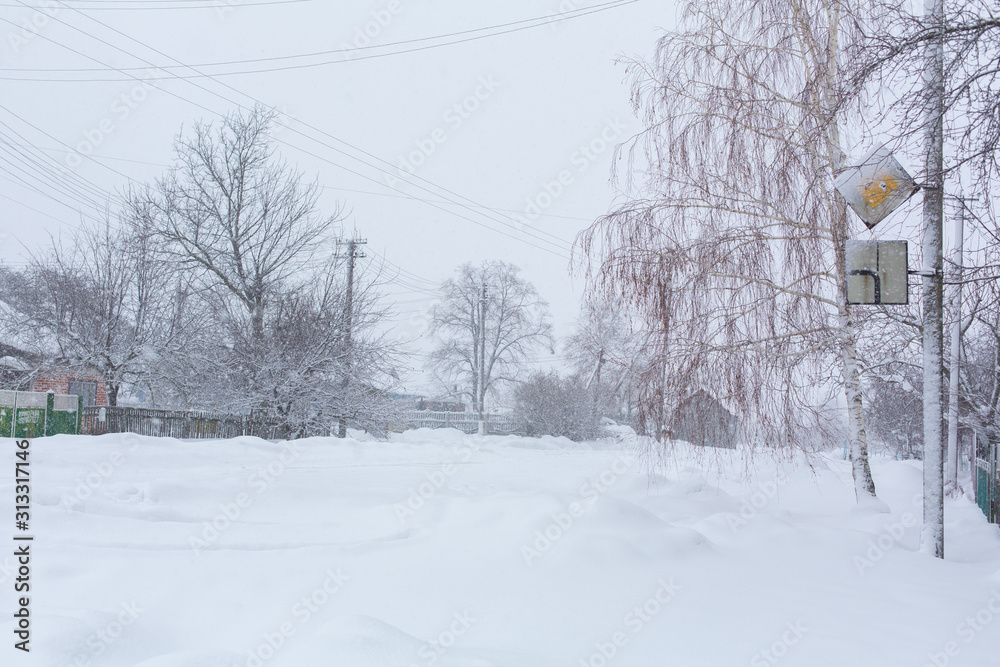 Winter, rural streets are covered with snow. Snow blizzard