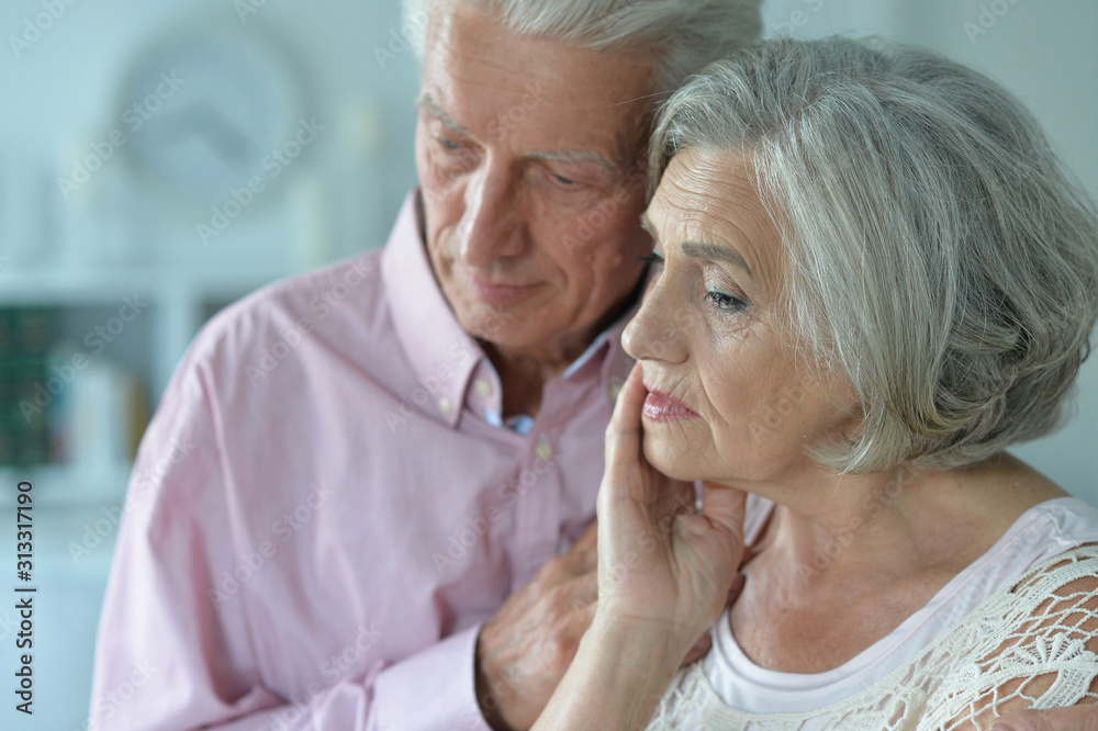 Close up portrait of unhappy senior couple posing at home
