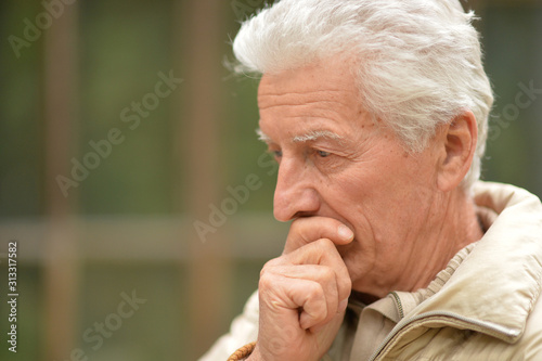 Close up portrait of serious senior man thinking 