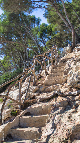 impression of the cami de cavalls, cala trebaluger, stone steps, menorca spain balearic islands photo
