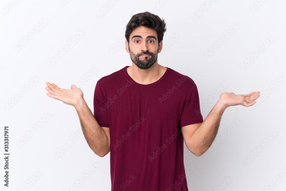 Young handsome man with beard over isolated white background having doubts while raising hands Young handsome man with beard over isolated white background having doubts while raising hands
