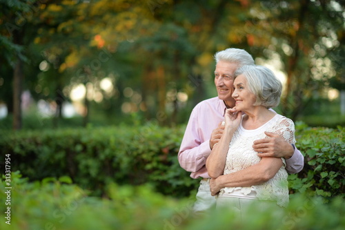 Happy senior woman and man hugging in park