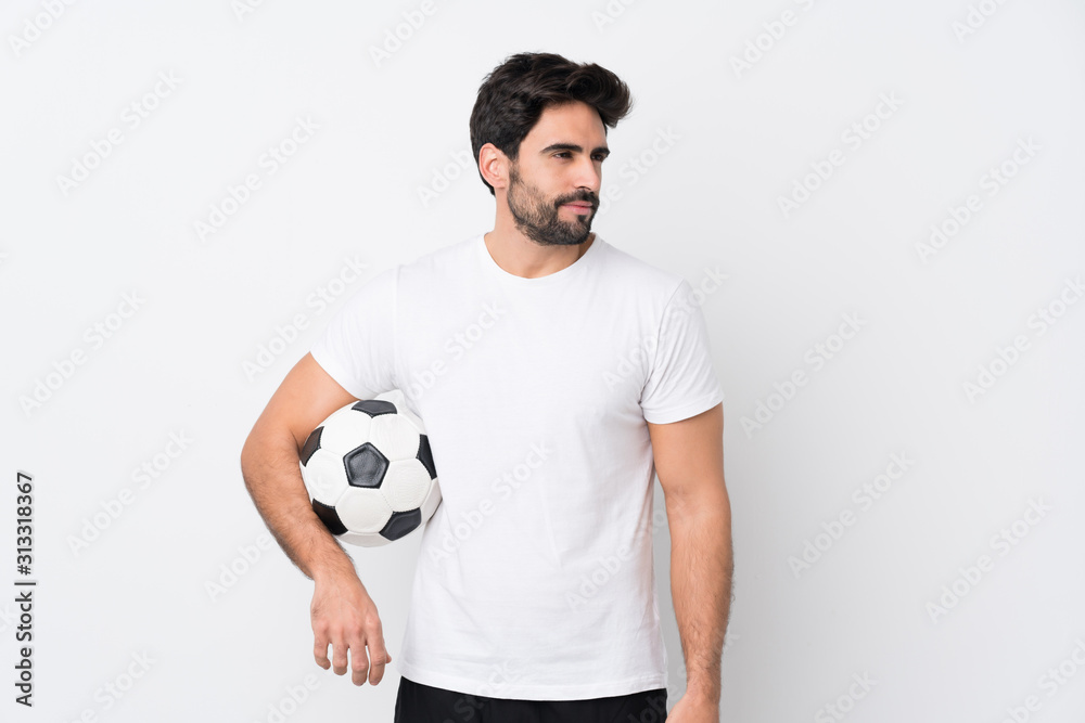 Young handsome man with beard over isolated white background with soccer ball