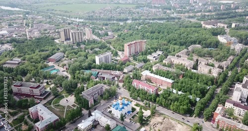 View from drone of Voskresensk cityscape with golden domes of Church of Icon of Our Lady of Jerusalem on spring day, Russia