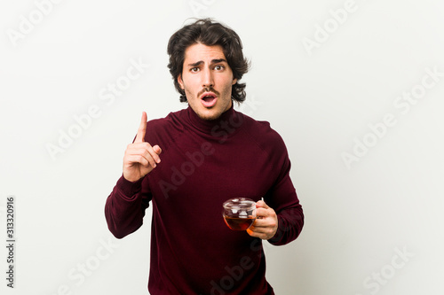 Young man holding a tea cup having an idea, inspiration concept.