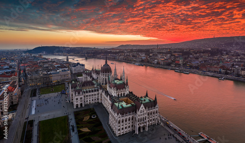Budapest, Hungary - Aerial panoramic drone view of the Hungarian Parliament building on a winter afternoon with an amazing dramatic colorful gold and red sunset sky